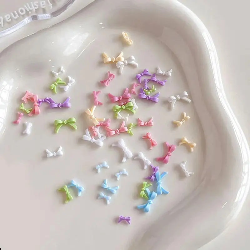 50pcs Colorful Bow Nail Art Parts Charms Bulk Shiny Mini Resin Ribbon Nail Rhinestones DIY Summer Nail Art Decor Accessories Vue